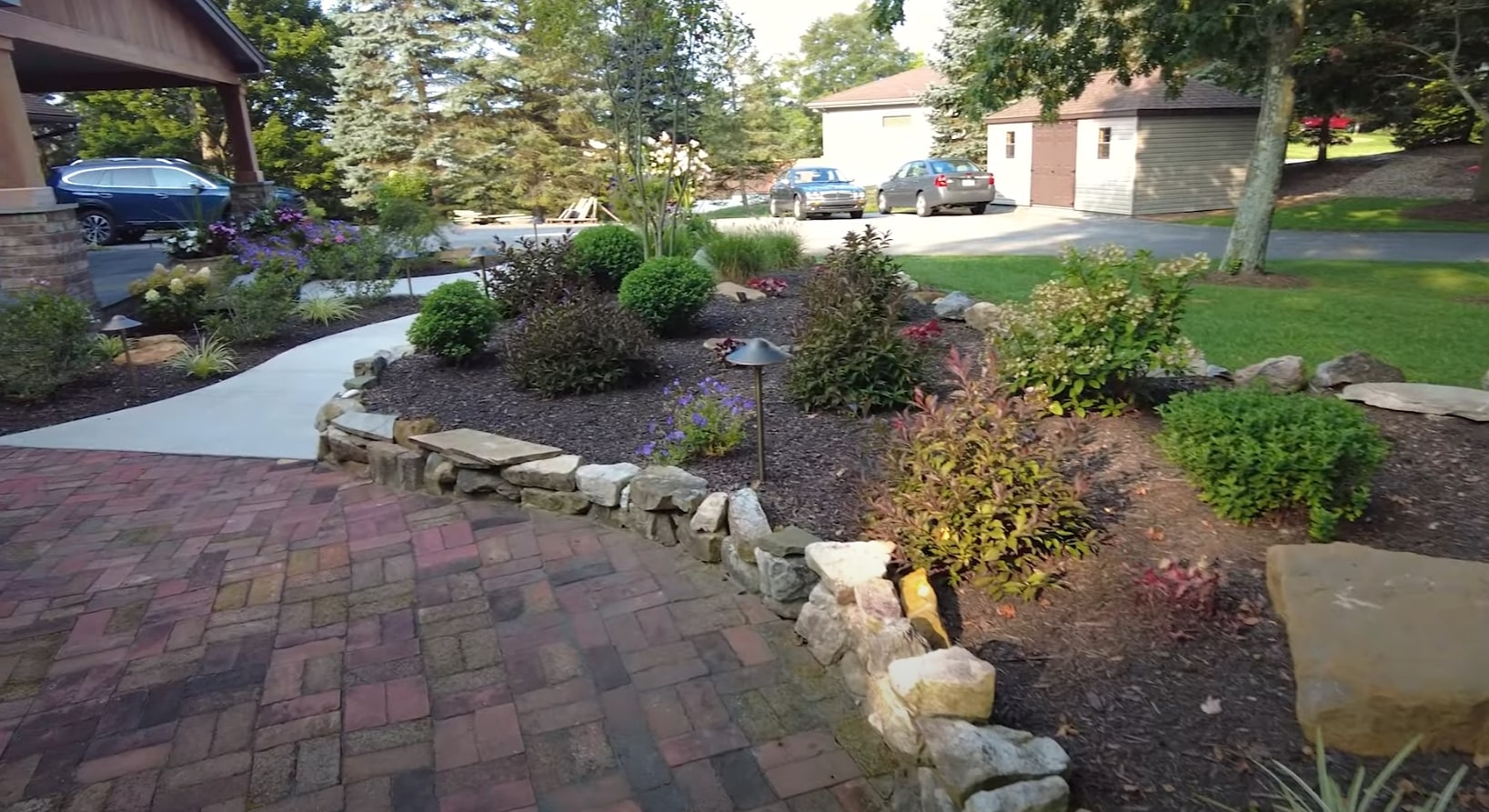 Front yard landscape design incorporating natural stone drainage features Professional front yard landscaping with stone features and drainage solutions in Channelview, TX