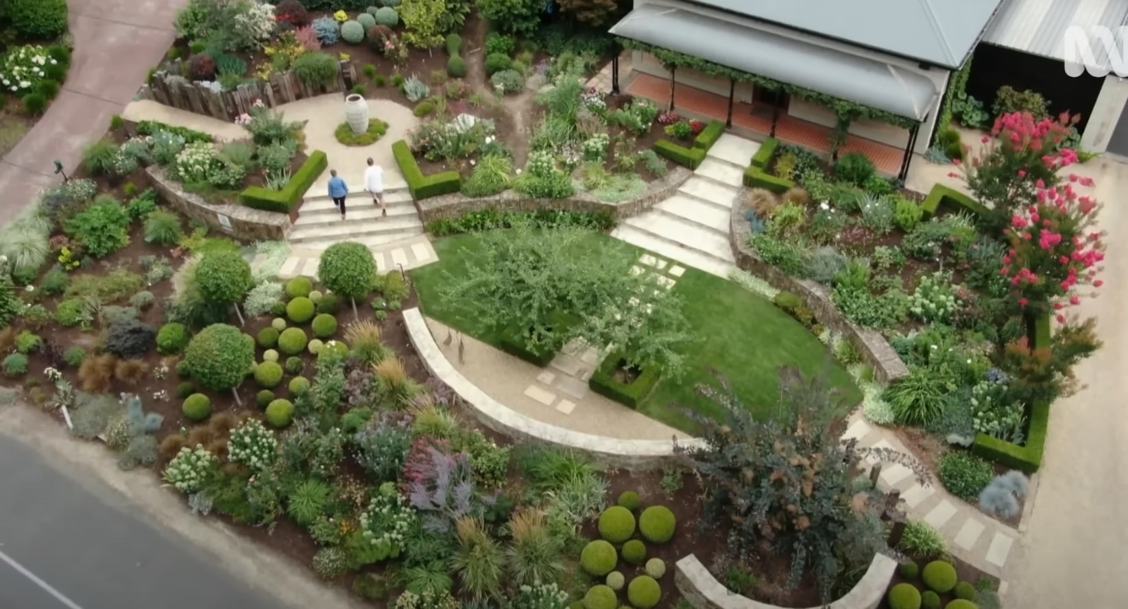 Professional landscape design featuring terraced gardens with curved walkways and mixed plantings Aerial view of terraced garden design with curved pathways and diverse plantings in Channelview, TX