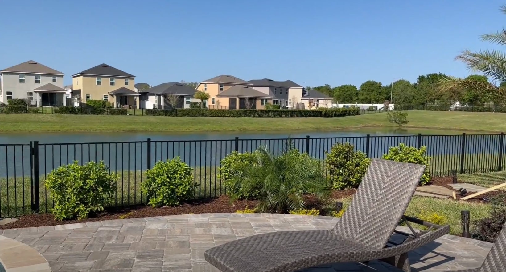 Professional residential landscape maintenance with pool and patio areas Beautiful residential landscaping with manicured lawn and pool area in Channelview, TX