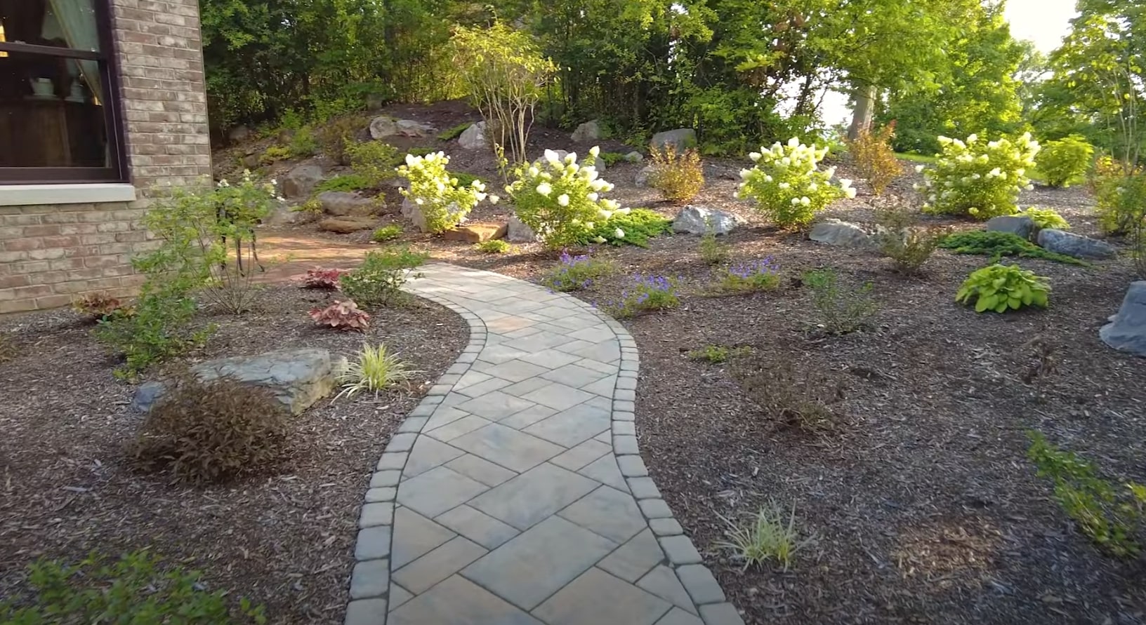 Natural stone walkway installation with integrated landscape lighting and native plant selections Natural stone pathway with landscape lighting and native plantings in Channelview, TX